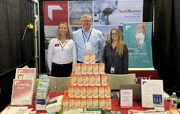 Employees stand at a NorthWestern Energy booth at a home and garden show.